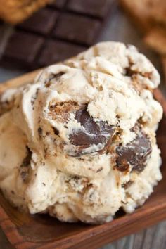 chocolate chip ice cream on a wooden plate with cookies in the backgroung