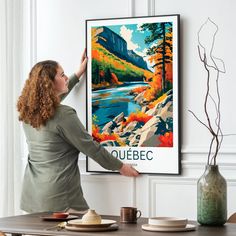 a woman standing in front of a poster with the name quebec on it