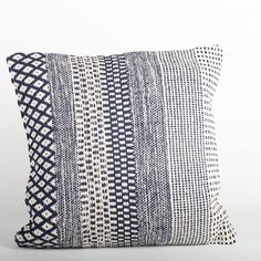 a blue and white pillow on a white background