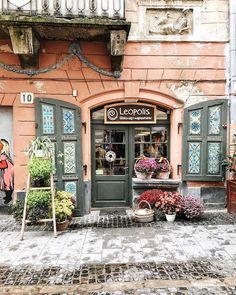 an old building with lots of potted plants outside