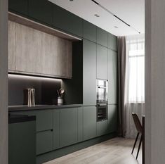 a kitchen with green cabinets and wooden flooring, along with a dining room table