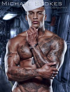 a man with tattoos on his chest and arms