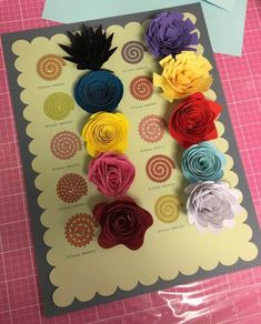 the paper flowers are arranged in different colors