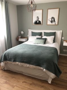 a bed with two pictures on the wall above it