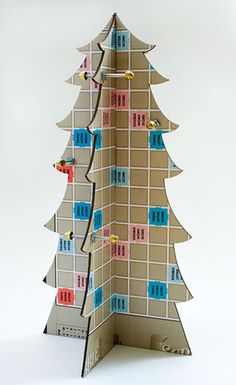 an origami christmas tree made out of pieces of cardboard and colored stickers