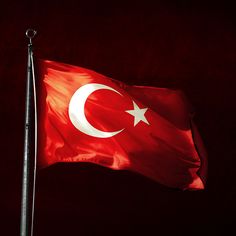 the flag of turkey is waving in the wind on a dark night with no one around it