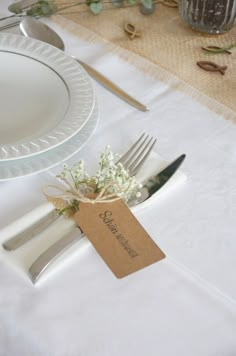 the place setting is set with silverware and flowers