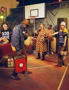 a group of people standing around each other in front of a basketball court with luggage