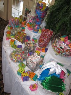 a table topped with lots of candy and candies on top of a white table cloth