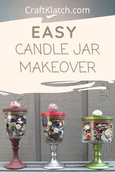 three glass jars with buttons in them sitting on a table next to a sign that says easy candle jar makeover