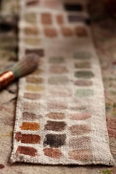 a close up of a table cloth with a brush on the ground next to it