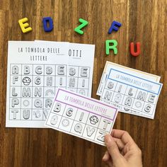 two sheets of paper with letters and numbers on them next to some colored magnets