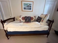 a bed sitting in the middle of a room with pillows on it's headboard