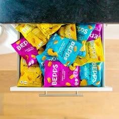 a bunch of candy bars are stacked in a bin on the counter top, ready to be eaten