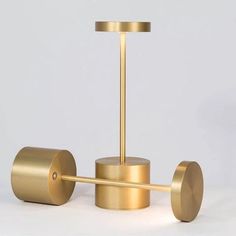 two brass toilet paper holders on a white surface with one holding a towel bar and the other holding a roll of toilet paper