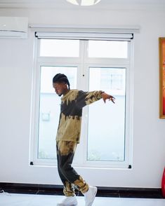 a young man is dancing in front of a window