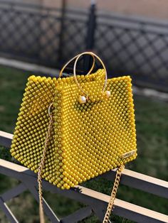 a yellow handbag sitting on top of a wooden fence