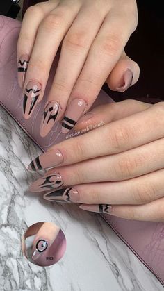 a woman's hands with pink and black nail designs on them, holding onto her purse