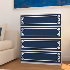 a white couch sitting next to a blue and white dresser in a living room on top of a hard wood floor