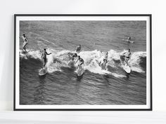 black and white photograph of surfers on their surfboards in the ocean with waves