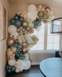 the balloon wall is filled with balloons and greenery for an elegant touch to any room