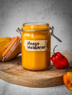 a jar filled with mango hababura sitting on top of a wooden cutting board