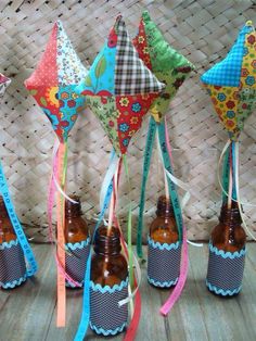 four brown bottles filled with beer sitting on top of a wooden table next to some colorful kites