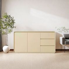 a living room with white furniture and a potted plant