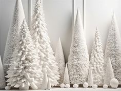 white christmas trees lined up against a wall