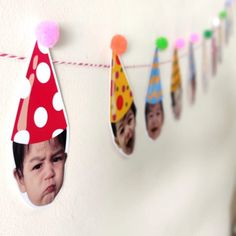 a child's birthday party hat hanging from a line with photos on the clothesline