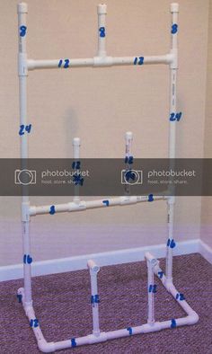 a white pipe rack with blue piping on the floor in front of a wall