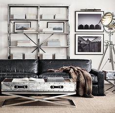 a living room with black leather furniture and pictures on the wall