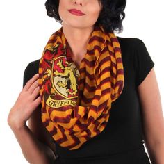 a woman wearing a harry potter scarf with her hands in her pockets and the words gryffin on it