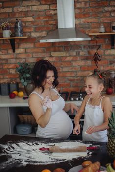 a pregnant woman and her daughter are preparing food