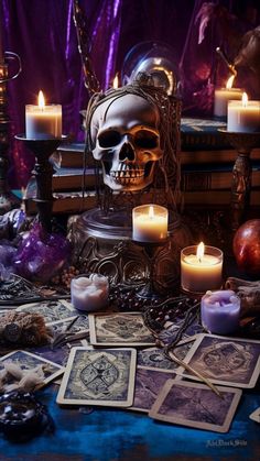 a table topped with lots of candles next to books and skulls on top of them