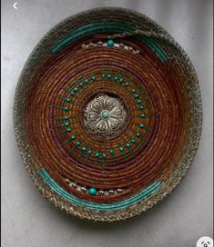 a brown and green bowl sitting on top of a white table next to a wall