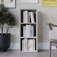 a bookshelf in the corner of a room next to a chair and potted plant