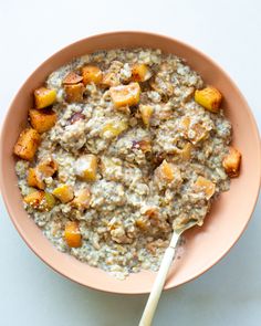 a bowl filled with oatmeal and fruit on top of a white table