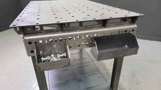 a metal table with holes in the middle and two trays on it's sides