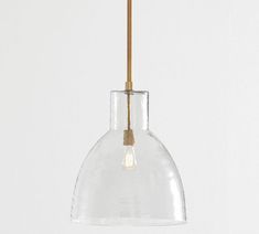 a clear glass pendant light hanging from a wooden rod on a white wall with a brown cord