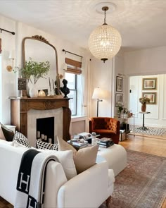 a living room filled with furniture and a fire place in front of a mirror on the wall