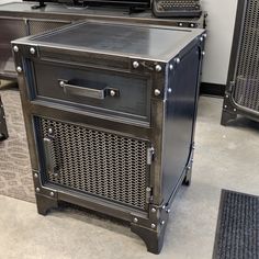 a black cabinet sitting on top of a floor next to other metal boxes and cabinets