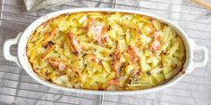 a casserole dish with chicken and potatoes on a cooling rack next to a spoon