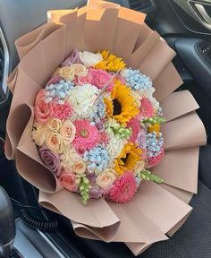 a bouquet of flowers sitting on the dashboard of a car