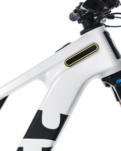 the front end of a white and black bike with an orange handlebar on it