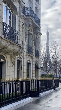 the eiffel tower is seen in the background from this street corner apartment building