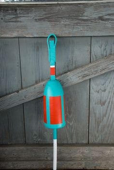 a blue and red umbrella on top of a wooden bench next to a wall with wood planks