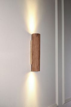 a wooden block mounted to the side of a white wall with two lights on it