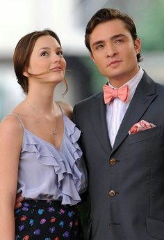 a man in a suit and tie standing next to a woman wearing a bow tie