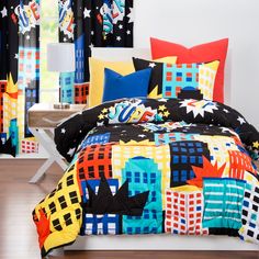 a bed room with a neatly made bed and colorful comforter set on it's side